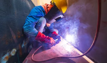 Trabajador utilizando equipos de protección en un espacio confinado con atmósfera peligrosa