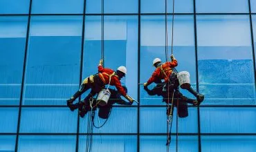 Dos trabajadores de trabajos en altura con un factor de caída reducido debido al buen uso de su equipo de protección personal Dos profesionales en trabajos en altura, garantizan su seguridad mediante un adecuado equipo de protección personal, reduciendo significativamente su factor de caída.