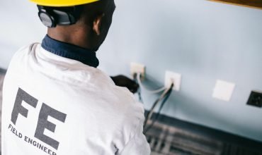 Trabajador de prevención de riesgos eléctricos evaluando la intensidad de la corriente alterna.