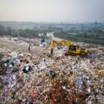 Tractor en un vertedero recolectando residuos sólidos en Perú